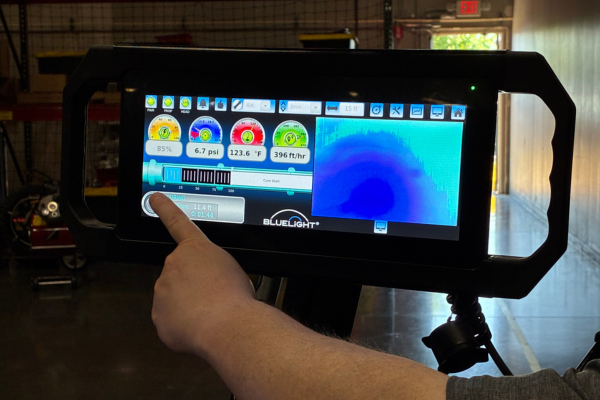 Person pressing the button on the Bluelight system screen to start the curing process.